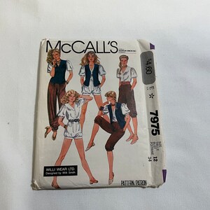 May include: McCall's sewing pattern envelope for a women's clothing pattern. The pattern number is 7975 and the size is 12. The pattern is for a top and pants. The envelope features a photo of five women modeling the pattern.