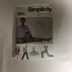 May include: A sewing pattern for women's pajamas with a purple and white print. The pattern includes a long-sleeved top and pants. The pattern is from Simplicity @Home and is for sizes PP (12, 14, 16, 18).
