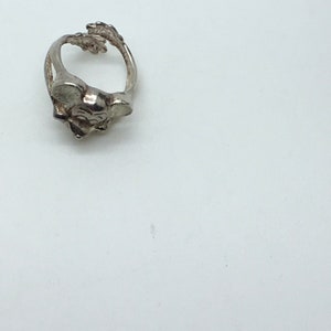 May include: A silver ring featuring a detailed mouse design. The ring is made of metal and has a smooth finish.