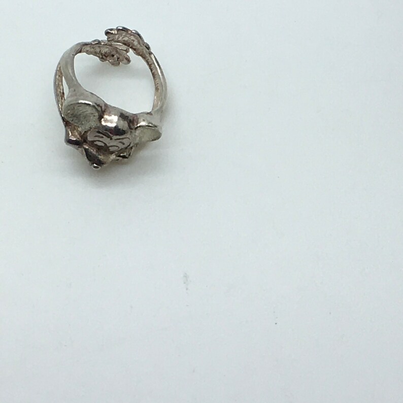 May include: A silver ring featuring a detailed mouse design. The ring is made of metal and has a smooth finish.