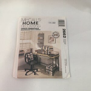 May include: A McCall's Home Decorating pattern for office essentials. The pattern includes instructions for making a desk organizer, a chair cushion, a footstool, and a window valance. The pattern is for size 2662.