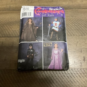 May include: Simplicity 5620 sewing pattern for children's costumes. The pattern includes four costumes: a princess, a knight, a warrior, and a queen. The pattern is printed on white paper with black and red text.
