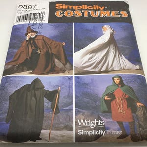 May include: A sewing pattern booklet for Simplicity Costumes, featuring four different costume designs. The cover shows a wizard, a hooded figure, a white hooded cloak, and a hooded figure in a green and red costume. The text on the cover reads "Simplicity Costumes" and "Wrights Simplicity Trims".