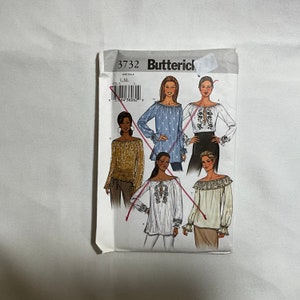May include: A sewing pattern for four different tops with long sleeves and off-the-shoulder necklines. The pattern is from Butterick and the pattern number is 3732. The tops are shown in different colors and patterns, including blue, white, brown, and beige.