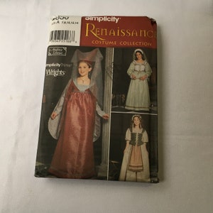 May include: A Simplicity Renaissance Costume Collection sewing pattern envelope, size A 7, 8, 10, 12, 14. The front displays three variations of historical-style dresses with long sleeves, bodices, and headpieces, featuring red, white, and green fabric.