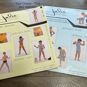 May include: Two sewing pattern books with the brand name "Jalie". One is light yellow and the other is light blue. The yellow book is labeled "Slip - garçon/boy" and the blue book is labeled "amisolet caleçon long under shirt and drawers". Both books feature illustrations of children.