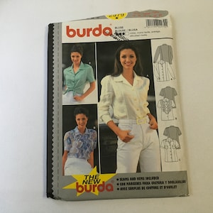 May include: A sewing pattern for a blouse with three different styles. The pattern is from Burda Style magazine and includes instructions for sewing seams and hems. The pattern is for sizes 10-20.