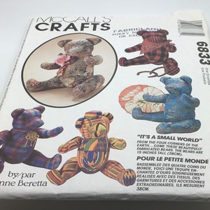 May include: McCall's Crafts pattern envelope with fabric bear designs. The bears are in various colours and patterns, with text that reads "It's a Small World" and "The bears are 38cm tall." The envelope also includes the name "Joanne Beretta."