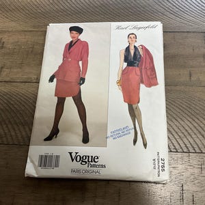 May include: A vintage Vogue Patterns sewing pattern featuring designs by Karl Lagerfeld. The cover showcases illustrations of women in stylish suits. The pattern includes a skirt suit and a jacket suit. The text "PARIS ORIGINAL" is visible.