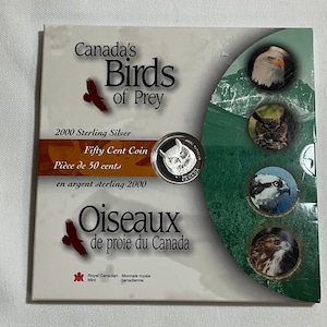 May include: A 2000 Sterling Silver Fifty Cent Coin from Canada, featuring an owl design. The packaging includes the text "Canada's Birds of Prey" in English and French, along with images of various birds of prey.