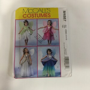 May include: A McCall's Costumes pattern envelope featuring four fairy costume designs for children. The envelope has a yellow top with the brand name and product number M4887. The costumes include wings and dresses in various colors.