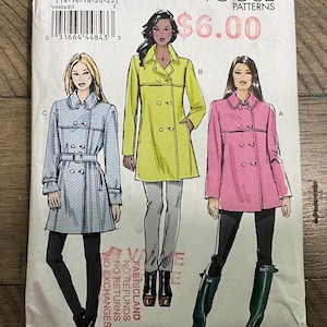 以下が含まれることがあります： ライトブルー、ライムグリーン、ピンクの3種類のダブルブレストコートのイラストが描かれたVogue Patternsの型紙封筒V8884。封筒にはV8884、E5、14-16-18-20-22、Vogue Patternsの文字とバーコードが記載されています。