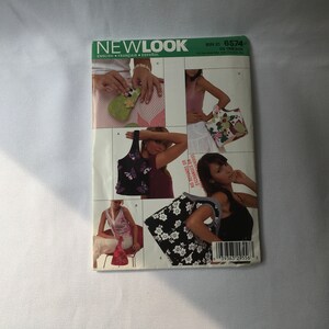 May include: A sewing pattern booklet for making different styles of bags. The cover features a photo of a woman holding a black and white floral tote bag. The pattern is for one size and is from Newlook.