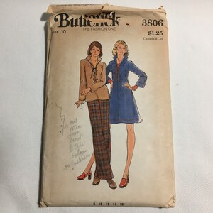 May include: Vintage sewing pattern for a dress and pants. The pattern is from the brand Butterick, and the pattern number is 3806. The pattern is for size 10. The dress is blue and the pants are plaid.
