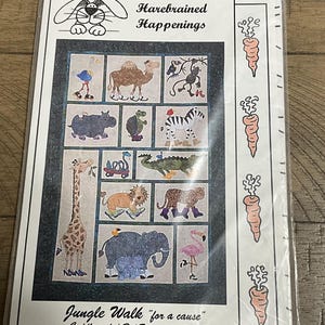 May include: A packaged quilt pattern titled "Jungle Walk" featuring whimsical animal illustrations. The quilt measures 51 x 77 inches. The pattern includes a giraffe, elephant, zebra, and other jungle animals. The package is sealed in clear plastic.