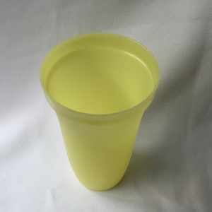 May include: A pale yellow plastic flower pot with a flared rim.