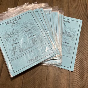 May include: A stack of sealed plastic bags containing light blue paper sheets. Each sheet features the title "Ladies of the Sea" and illustrations of sailing ships. The sheets also include text detailing the design and materials.