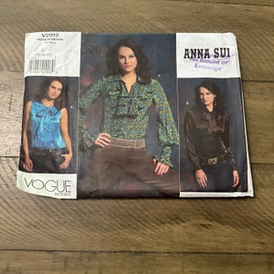 May include: Vogue Patterns sewing pattern for Anna Sui blouses. The pattern packet shows images of three blouse styles: a blue sleeveless top, a floral print blouse, and a brown satin blouse. The pattern number is V2912.