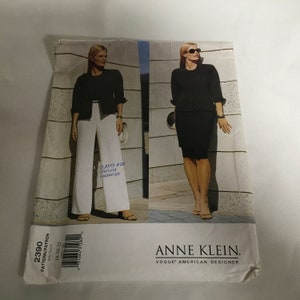 May include: A sewing pattern for a black jacket and skirt or pants. The pattern is from Anne Klein, a Vogue American Designer. The pattern number is 2390 and the sizes are 18, 20, and 22.
