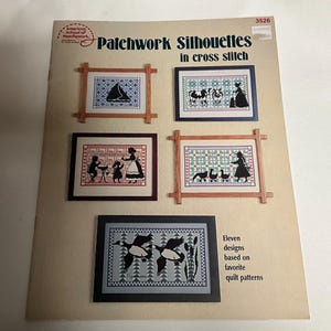 May include: A book cover with the title "Patchwork Silhouettes in cross stitch" and a picture of a framed cross stitch design of a sailboat. The book cover also includes the text "Eleven designs based on favorite quilt patterns".
