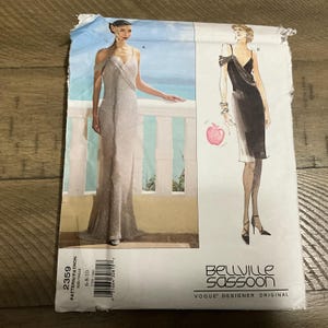May include: A vintage sewing pattern featuring two dress designs. One is a floor-length, silver-toned gown with a draped bodice. The other is a black, knee-length dress with an asymmetrical neckline. The pattern is labeled "Bellville Sassoon" and "Vogue Designer Original".