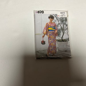 以下が含まれることがあります： ピンクと白の花柄の浴衣の型紙です。黄色の帯が付いています。サイズはS-M-Lです。ブランドは「epo」です。