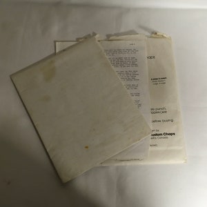 Op de afbeelding: Een witte envelop met een bruine vlek. De envelop is dubbelgevouwen en bevat een wit vel papier. Het papier bevat tekst die zegt "4 maten in elke Klein Medium Groot & Groot" en "pons. ippers (zie voordat u koopt am by custom Chaps erta, Canada uced)"