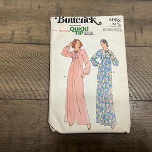 May include: A vintage Butterick sewing pattern, size medium, featuring illustrations of two long, flowing gowns. The pattern includes a "Quick Tip" for soft fabrics. The pattern number is 5982.