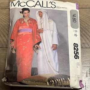 May include: A vintage McCall's sewing pattern envelope featuring illustrations of two figures in costume. One figure wears a red kimono with a purple sash, and the other wears a white robe. The envelope has the text "McCall's" and the number "8256".