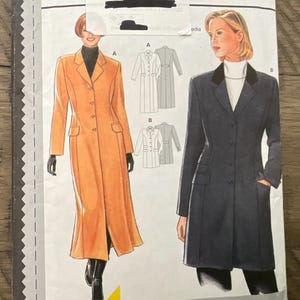 Op de afbeelding: Een Burda naaipatroon-envelop met illustraties van twee jassen. De ene is een lange oranje jas, de andere een kortere donkerblauwe jas met een zwarte kraag. De tekst bevat "**STAFF PATTERN**", "THE NEW burda" en "SEAMS AND HEMS INCLUDED".