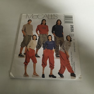 Könnte beinhalten: Ein Vintage-Schnittmusterumschlag von McCall's mit Illustrationen von Kleidung. Der Umschlag zeigt die Nummer 2635 und Größenangaben. Die Outfits umfassen T-Shirts, Sweatshirts und Hosen mit Kordelzug.