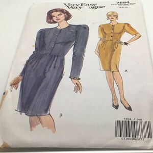 May include: A sewing pattern for a dress with two different styles. The first style is a long-sleeved dress with a button-up front and a fitted waist. The second style is a short-sleeved dress with a button-up front and a fitted waist. The pattern is for sizes 8-10 and is from Very Easy Very Vogue.
