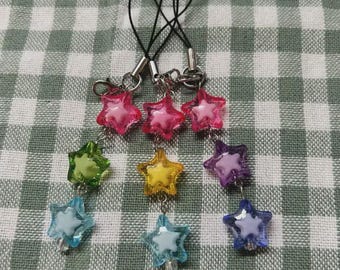 May include: Three phone charms featuring dangling star-shaped beads in various colors including pink, green, blue, yellow, and purple. Each charm is attached to a black cord with a silver-toned metal lobster clasp and jump rings.