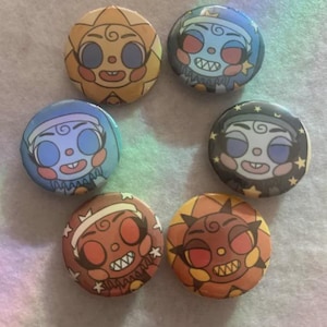 May include: Seven circular pin badges with cartoon sun and moon faces. The badges are in a variety of colours, including yellow, blue, and orange. Each face has a smiling expression and is set against a coloured background.