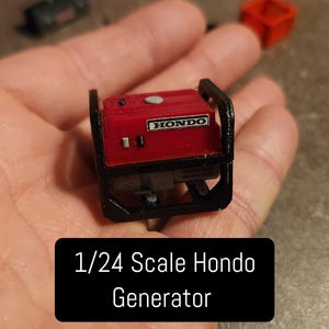 May include: A red and black 1/24 scale Honda generator model. The generator has a black frame and a red engine with the word "HONDO" printed on it.