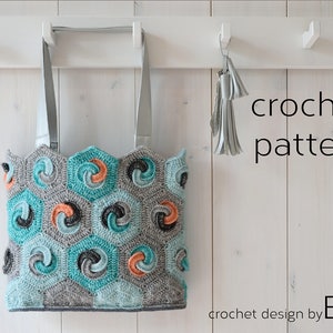 Könnte beinhalten: Eine Häkel-Tasche mit einem geometrischen Muster in Grautönen, Türkis und Orange. Die Tasche hat einen weißen Hintergrund und hängt an einem weißen Haken. Der Text "crochet pattern" ist in Schwarz auf der rechten Seite des Bildes geschrieben. Der Text "crochet design by BOR" ist in Schwarz am unteren Rand des Bildes geschrieben.