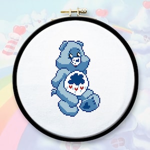 Puede incluir: Un oso azul Care Bear con una nube y gotas de lluvia en su vientre. El oso Care Bear sonríe y tiene una nariz y una boca azul claro.