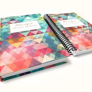 May include: Two colorful spiral bound journals with a geometric pattern on the cover. The cover of both journals says "Mindful Health Journal".