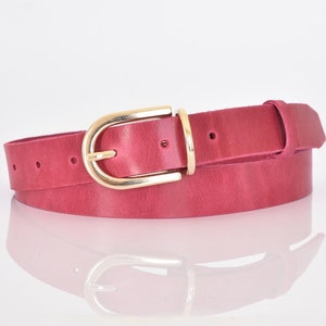 May include: A pink leather belt with a gold oval buckle.