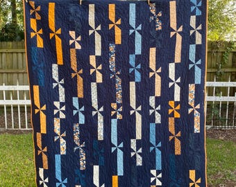 Trapunta fatta a mano con fiocchi e nastri moderni ovunque. Sfondo blu navy con fiocchi e nastri di diverse fantasie.