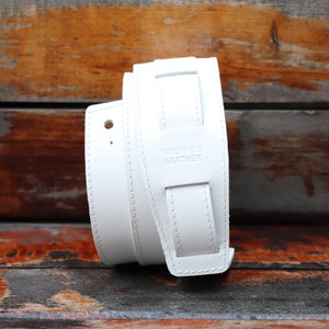 Op de afbeelding: Wit leren gitaarband met de tekst "Trooper's Leather" erop gegraveerd.