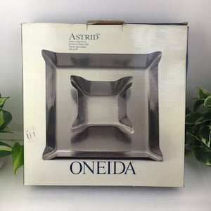 以下が含まれることがあります： シルバーカラーのチップ＆ディップサーバーセット。オリジナルの箱入りです。セットには、14 x 14インチ（約35.5 x 35.5 cm）の大きな正方形のトレイと、ユニークな形の小さなディップボウルが含まれています。「ASTRID」と「ONEIDA」のブランド名が箱に表示されています。