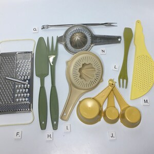 May include: A set of kitchen tools in green and yellow, including a grater, a spatula, a fork, a citrus juicer, a strainer, measuring cups, and a slotted spoon.