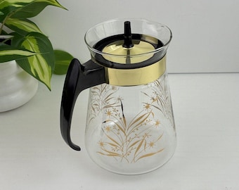 Cafetera de cristal Pyrex vintage de los años 50 con tapa, diseño floral dorado en forma de estrella, estilo MCM.