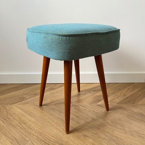 accent stool in turquoise yellow fabric and medium dark wood legs, Poland 1960, vintage mid century modern stool from the 60s, upholstered foot stool in melange turquoise fabric, stunning footrest in modern interior, design furniture for living room