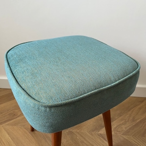 accent stool in turquoise yellow fabric and medium dark wood legs, Poland 1960, vintage mid century modern stool from the 60s, upholstered foot stool in melange turquoise fabric, stunning footrest in modern interior, design furniture for living room