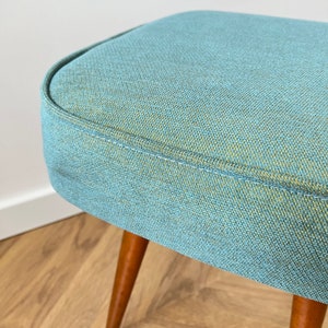 accent stool in turquoise yellow fabric and medium dark wood legs, Poland 1960, vintage mid century modern stool from the 60s, upholstered foot stool in melange turquoise fabric, stunning footrest in modern interior, design furniture for living room