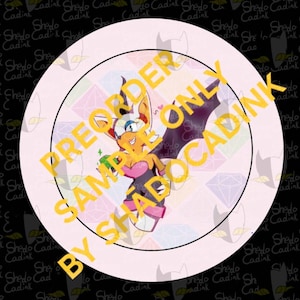 May include: A round, light pink graphic featuring a cartoon bat-like character holding a green gem. The character is orange, white, and black, with a pink heart. The text "PREORDER ONLY BY SHADOCADINK" is overlaid in yellow.
