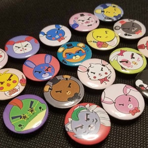 Könnte beinhalten: Eine Sammlung von 17 runden Anstecknadeln mit verschiedenen Comicfiguren mit wütendem Gesichtsausdruck. Die Figuren sind hauptsächlich Tiere, darunter ein Bär, ein Kaninchen, ein Huhn, ein Frosch und ein Schwein. Die Anstecknadeln sind bunt und haben verschiedene Hintergründe.
