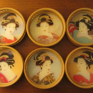Könnte beinhalten: Sechs runde Holz-Untersetzer mit Bambus-Design. Jeder Untersetzer zeigt ein anderes Bild einer Frau in traditioneller japanischer Kleidung.